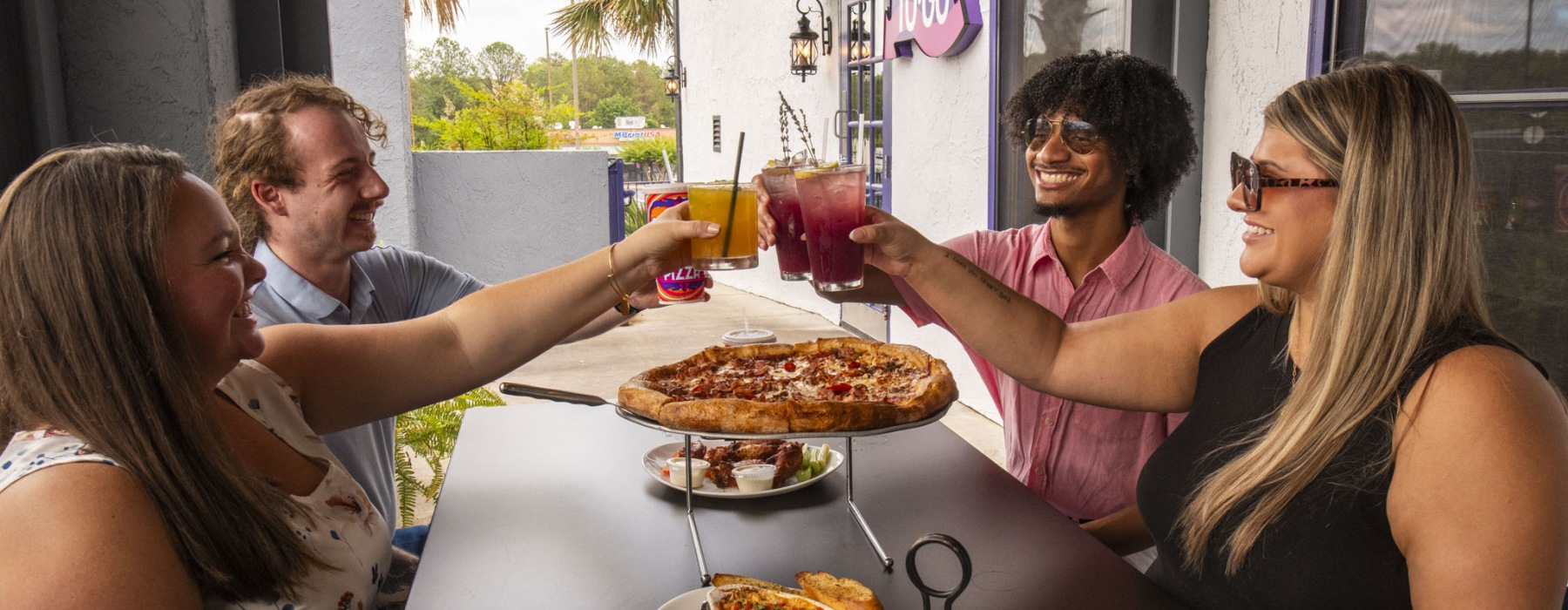 a group of people having a meal around an outdoor table