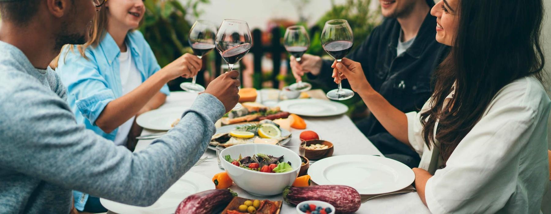 a group of people having a meal around an outdoor table